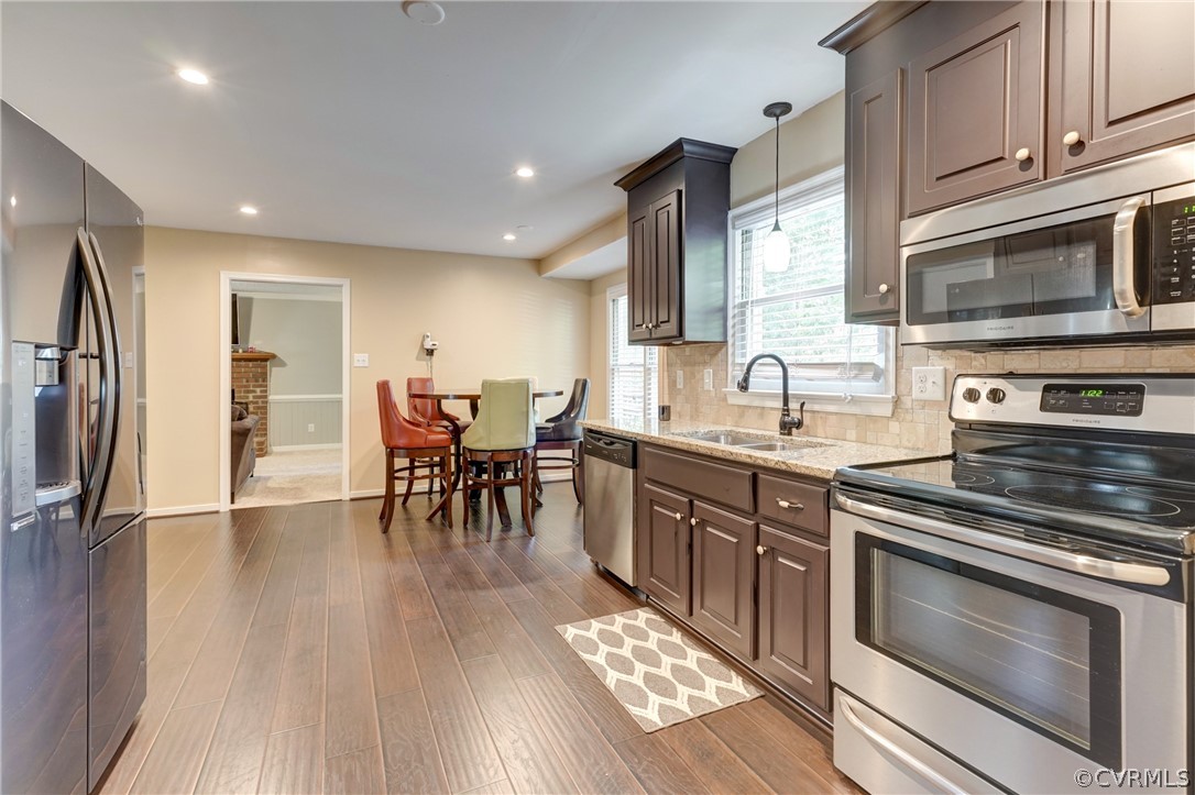 10618 Ridgerun Road Chesterfield, VA 23832 - Photo 13 of 36 a kitchen with stainless steel appliances granite countertop a stove a sink dishwasher a microwave oven and a refrigerator with wooden floor
