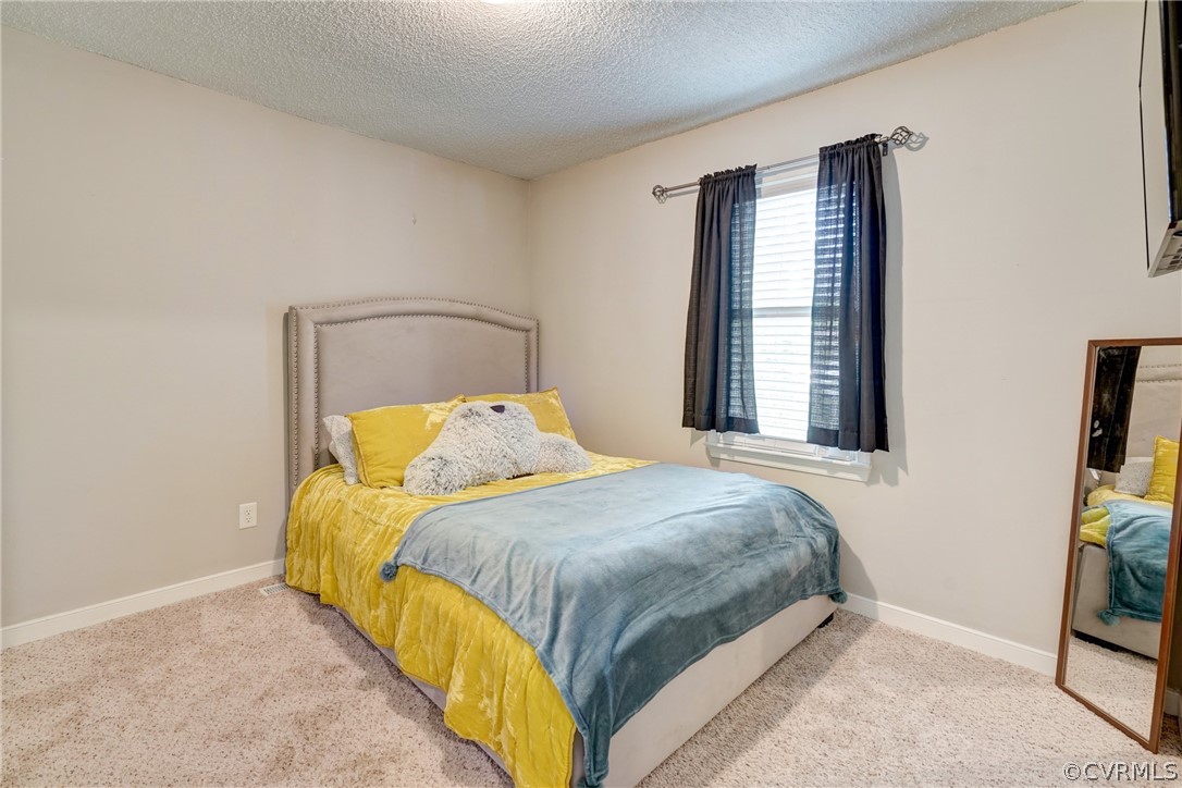 10618 Ridgerun Road Chesterfield, VA 23832 - Photo 20 of 36 a bed sitting in a bedroom next to a window