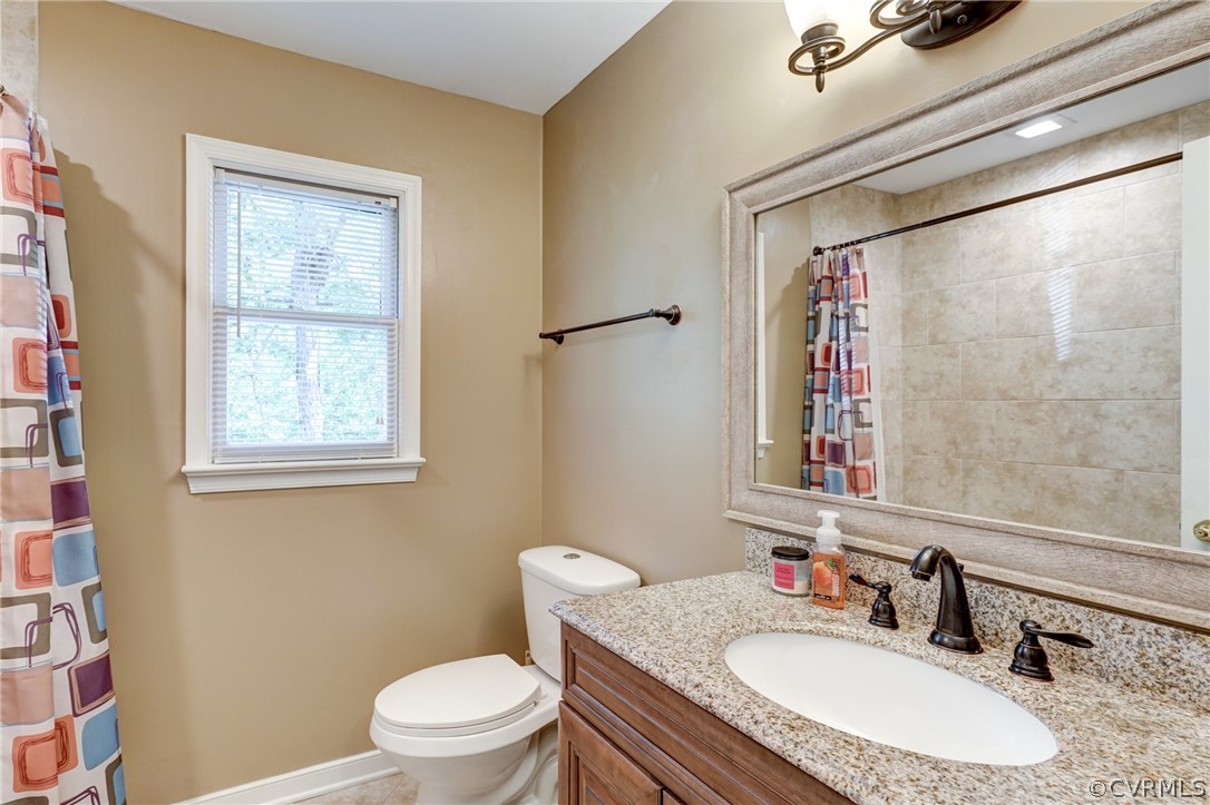 10618 Ridgerun Road Chesterfield, VA 23832 - Photo 25 of 36 a bathroom with a granite countertop sink toilet a mirror and a shower