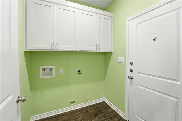 an empty room with wooden floor closet and windows