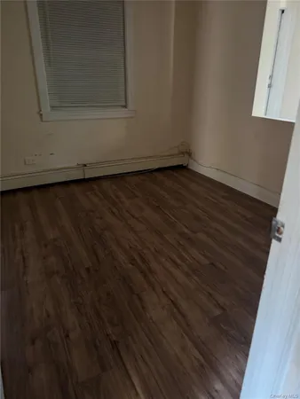 a view of a small space with wooden floor and a window