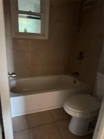 a white toilet sitting next to a bathtub