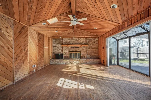 a view of a livingroom with wooden floor and a fireplace