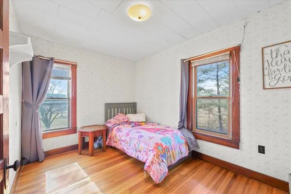 a bedroom with a bed and a large window
