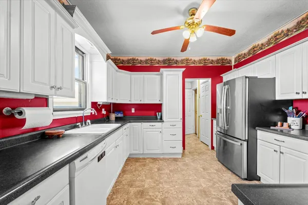 a kitchen with a sink refrigerator and cabinets