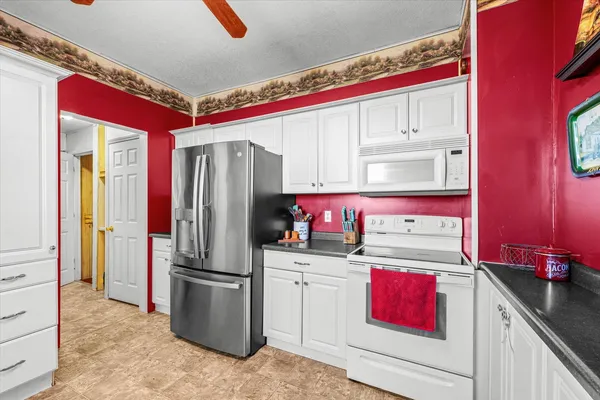 a kitchen with a refrigerator sink and cabinets