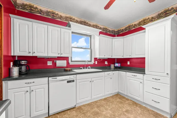 a kitchen with white cabinets and sink