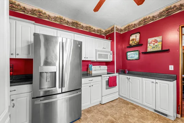 a kitchen with stainless steel appliances kitchen island granite countertop a refrigerator and a stove