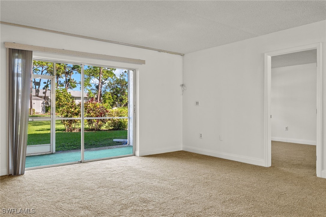 7068 Nantucket Circle, Unit 3 North Fort Myers, FL 33917 - Photo 2 of 17 a view of an empty room with wooden floor and a window