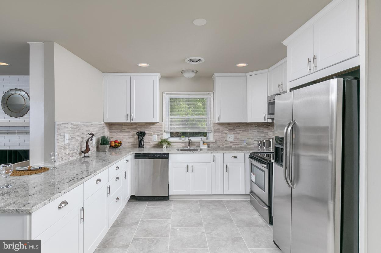 2801 Page Court Fallston, MD 21047 - Photo 16 of 30 a kitchen with granite countertop a refrigerator sink and white cabinets