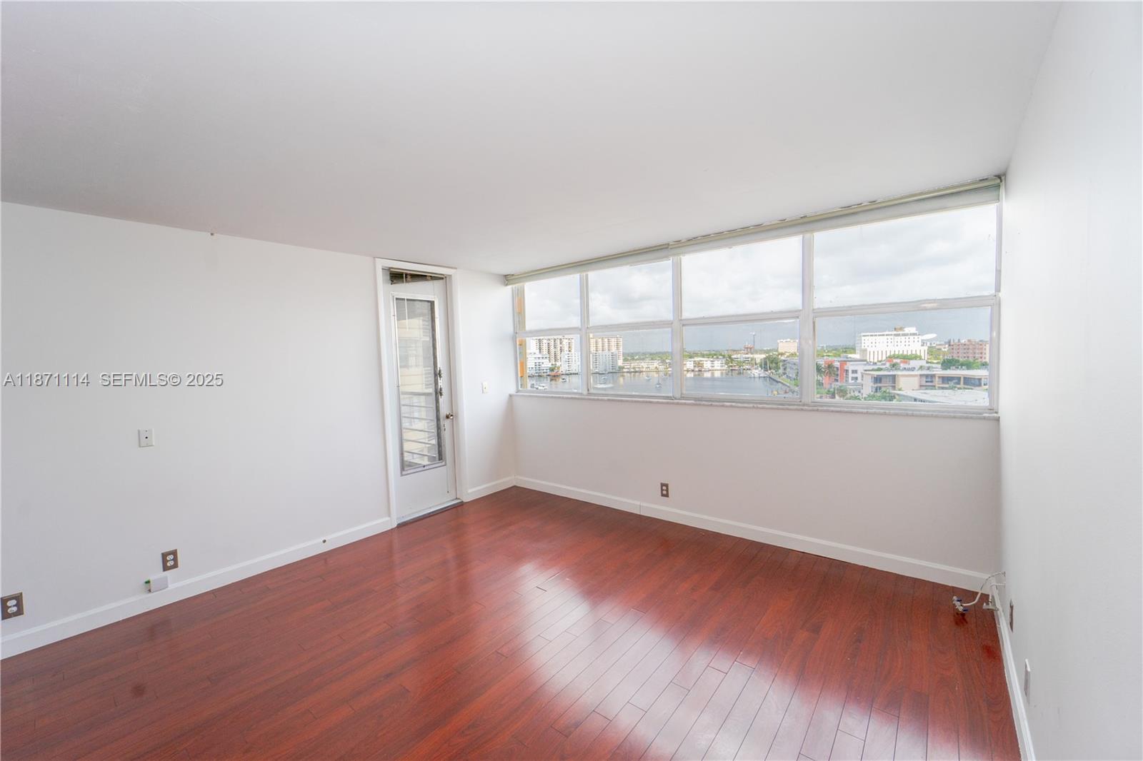 100 Golden Isles Drive, Unit 809 Hallandale Beach, FL 33009 - Photo 12 of 18 an empty room with wooden floor and windows