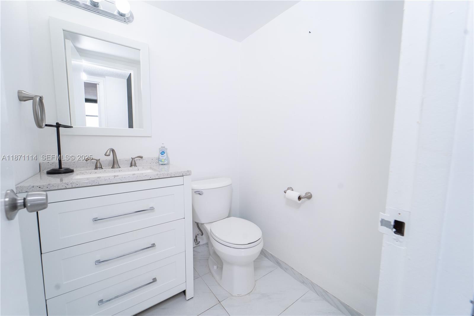100 Golden Isles Drive, Unit 809 Hallandale Beach, FL 33009 - Photo 15 of 18 a bathroom with a toilet sink vanity and mirror