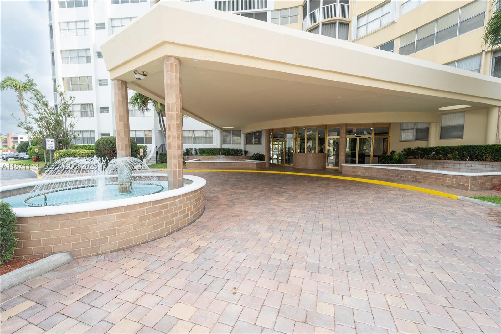 100 Golden Isles Drive, Unit 809 Hallandale Beach, FL 33009 - Photo 2 of 18 a view of a white building with swimming pool in front of it