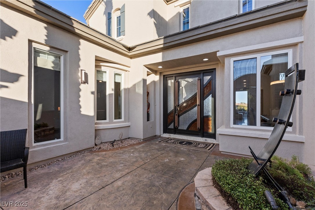 1911 Alcova Ridge Drive Las Vegas, NV 89135 - Photo 4 of 43 View of exterior entry with a patio area and stucco siding