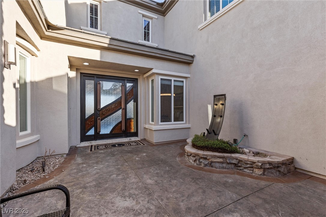 1911 Alcova Ridge Drive Las Vegas, NV 89135 - Photo 5 of 43 Property entrance with a patio and stucco siding