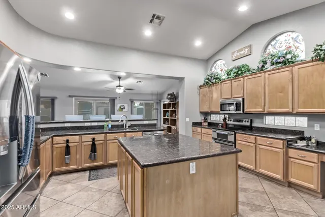a kitchen with granite countertop a stove sink and refrigerator
