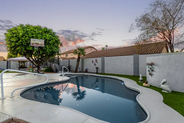 a view of a house with pool and sitting area