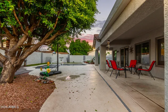 a view of a patio with a table and chairs under an umbrella