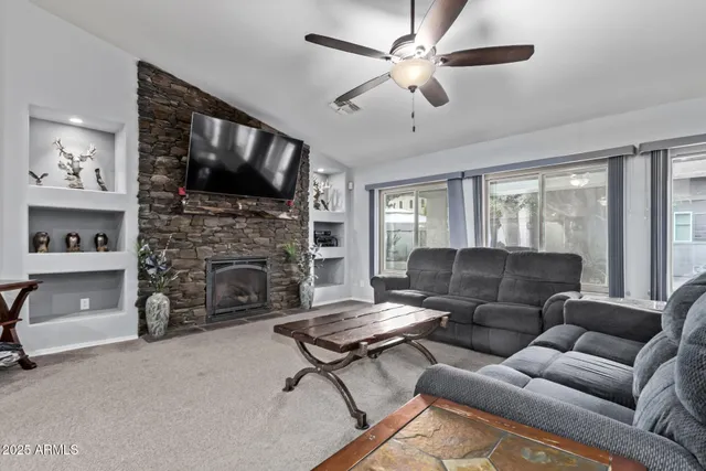 a living room with furniture a flat screen tv and a fireplace
