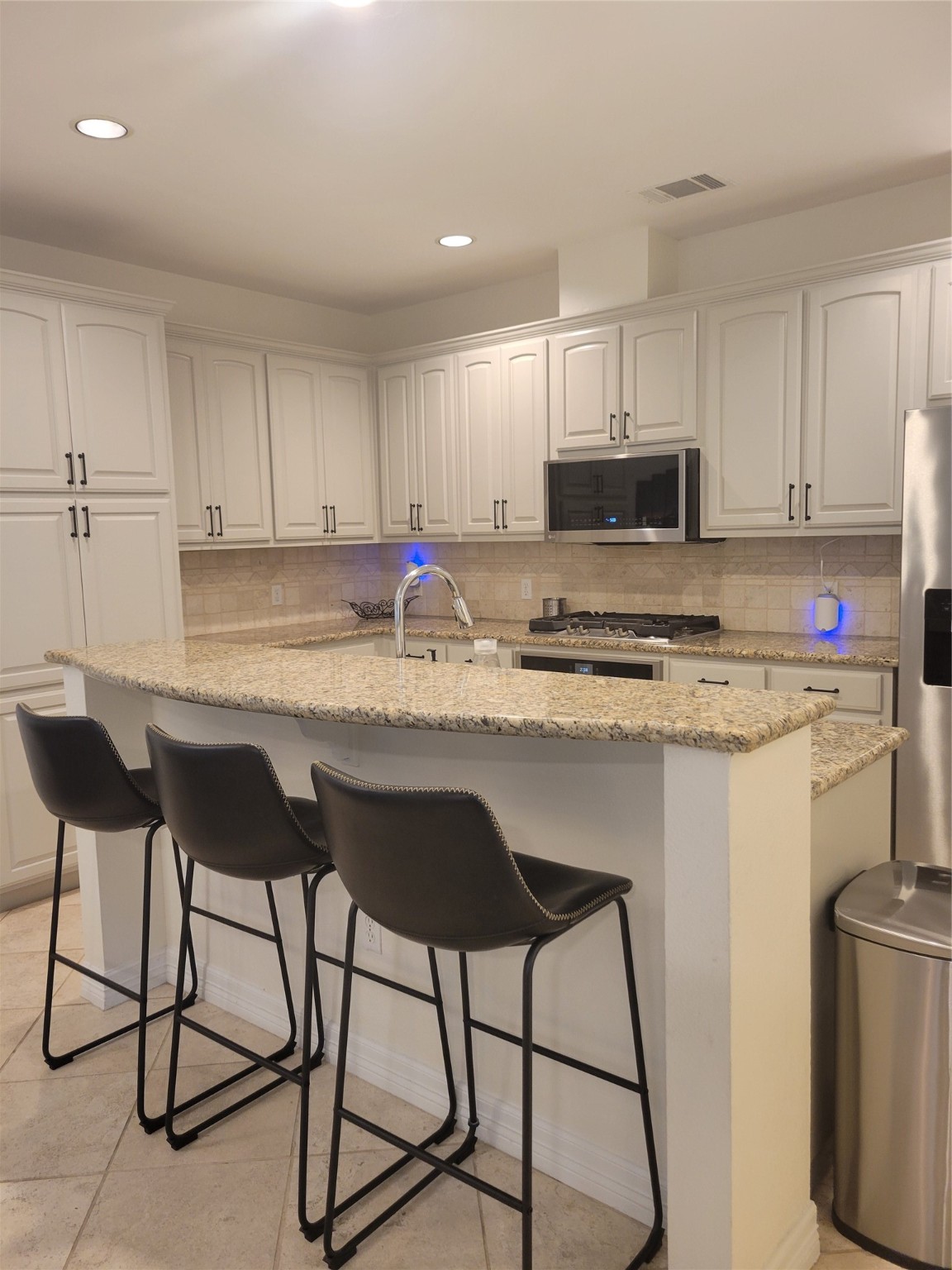 3203 Tom Green Street, Unit 3A Austin, TX 78705 - Photo 12 of 33 a kitchen with stainless steel appliances granite countertop a stove a sink and a refrigerator