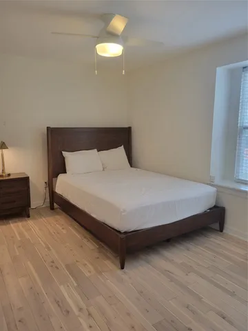 a large bed sitting in a room next to a lamp