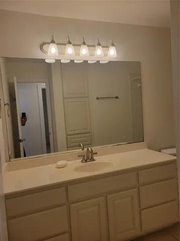 a bathroom with a sink vanity and a mirror