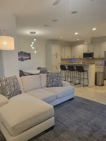 a living room with furniture and kitchen view