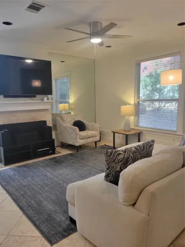 a living room with furniture a fireplace and a flat screen tv