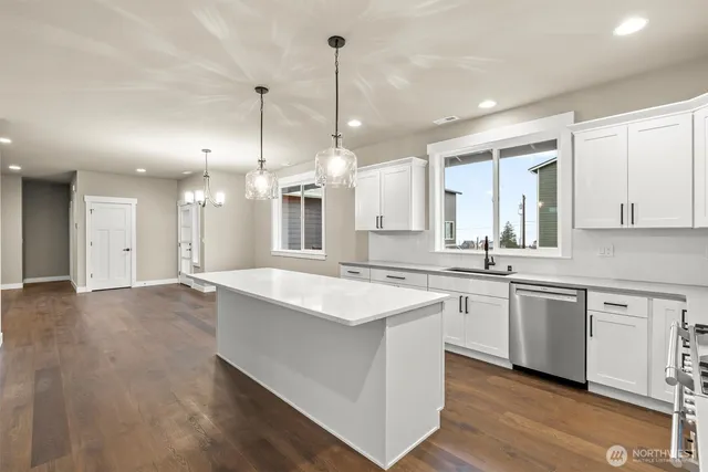 a large kitchen with kitchen island a sink a center island a stove and a wooden cabinets