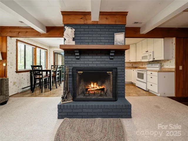 a living room with furniture a fireplace and kitchen view