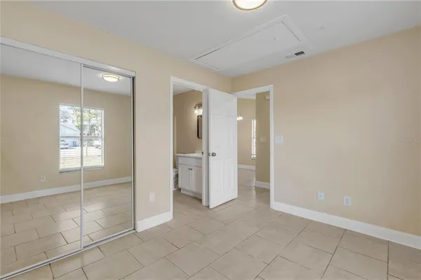 an empty room with closet and a chandelier fan