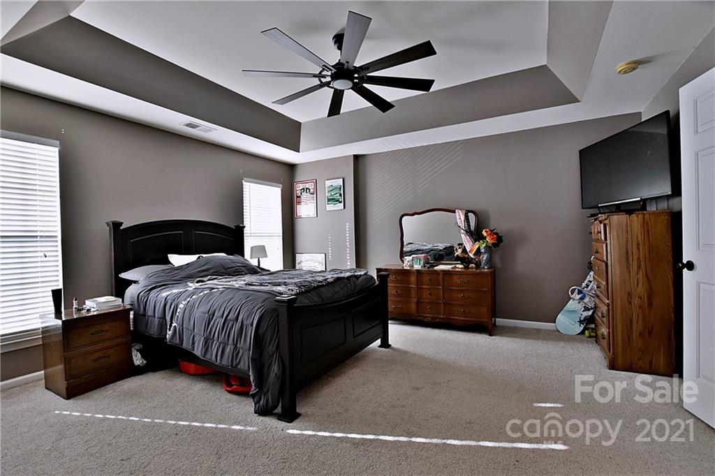 828 Dillard Road Rock Hill, SC 29730 - Photo 11 of 16 a bedroom with a bed and a flat tv screen on the dresser