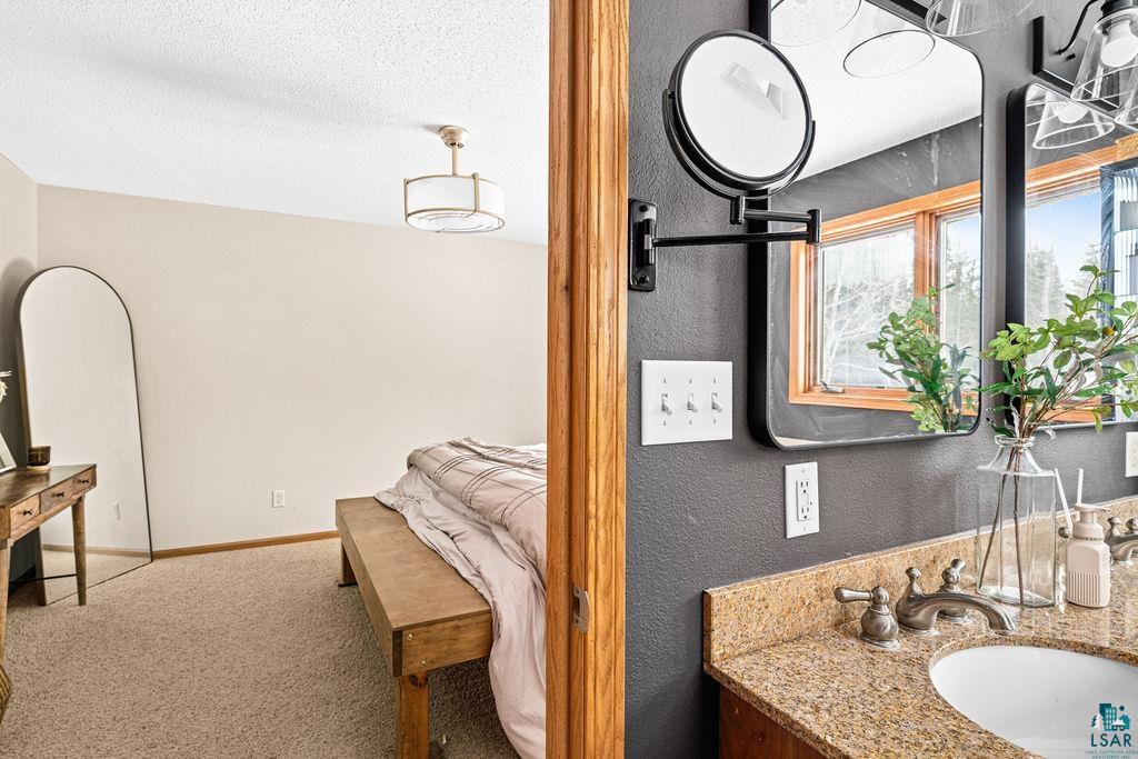 2783 Lauren Road Duluth, MN 55804 - Photo 21 of 47 Bathroom with vanity, carpet floors, a textured ceiling, and a textured wall