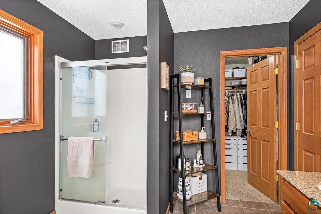 2783 Lauren Road Duluth, MN 55804 - Photo 26 of 47 Bathroom with vanity, a stall shower, and a spacious closet