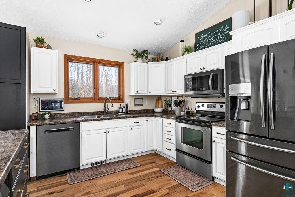 2783 Lauren Road Duluth, MN 55804 - Photo 3 of 47 Kitchen with stainless steel appliances, white cabinets, dark wood-type flooring, and dark stone counters