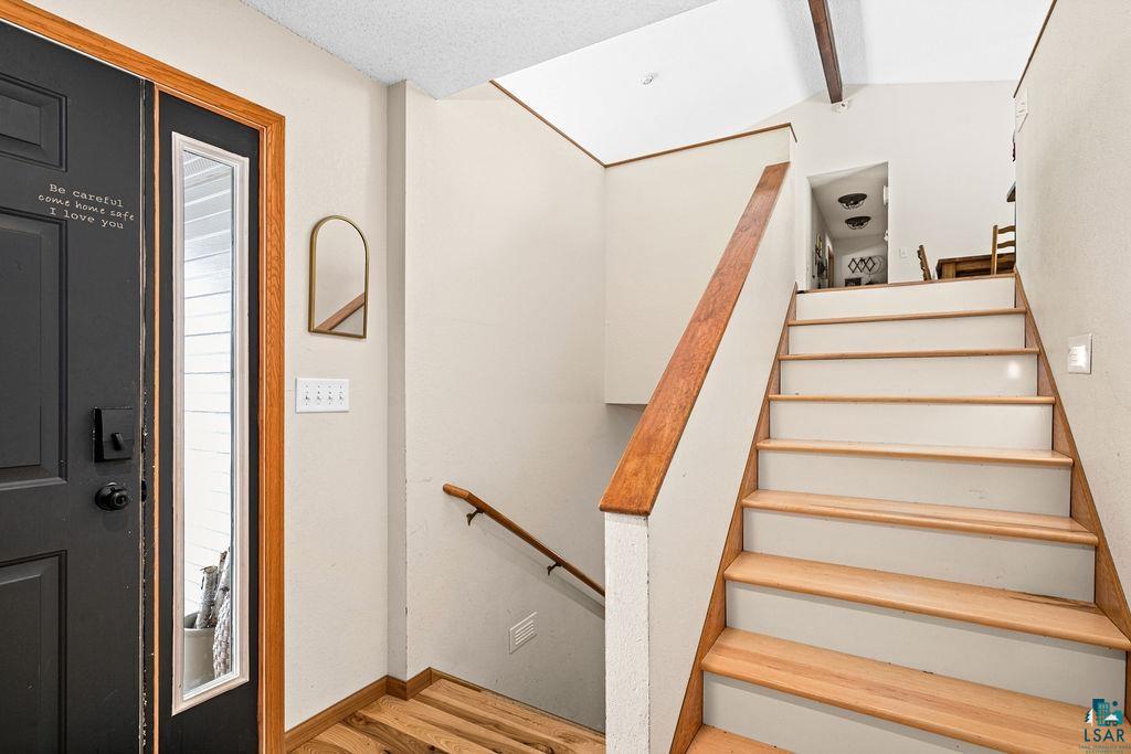 2783 Lauren Road Duluth, MN 55804 - Photo 34 of 47 Stairway with wood finished floors and beam ceiling
