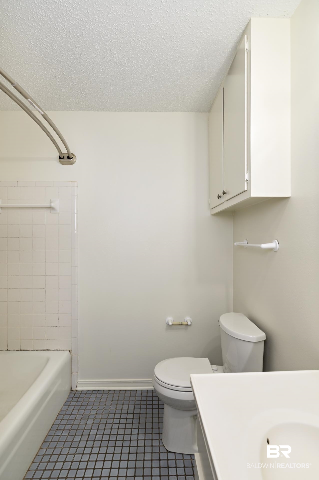707 Johnson Avenue Fairhope, AL 36532 - Photo 25 of 38 Full bathroom featuring a textured ceiling, vanity, toilet, tile patterned floors, and shower / bathing tub combination