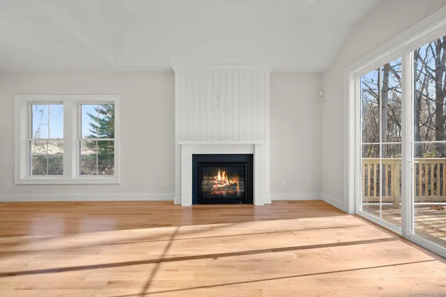 a large kitchen with a fireplace and wooden floor
