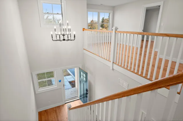 a view of a hallway with wooden floor and staircase