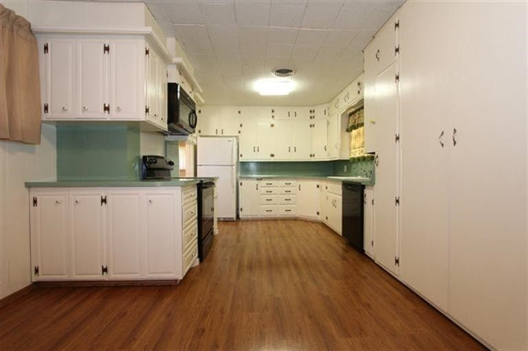 3004 36th Street Lubbock, TX 79413 - Photo 5 of 10 a kitchen with stainless steel appliances white cabinets and wooden floors