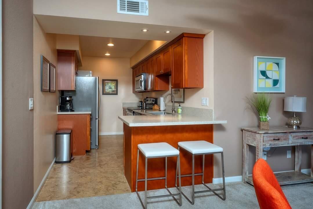 351 North Hermosa Drive, Unit 2A2 Palm Springs, CA 92262 - Photo 11 of 17 a kitchen with stainless steel appliances granite countertop wooden cabinets sink and stove