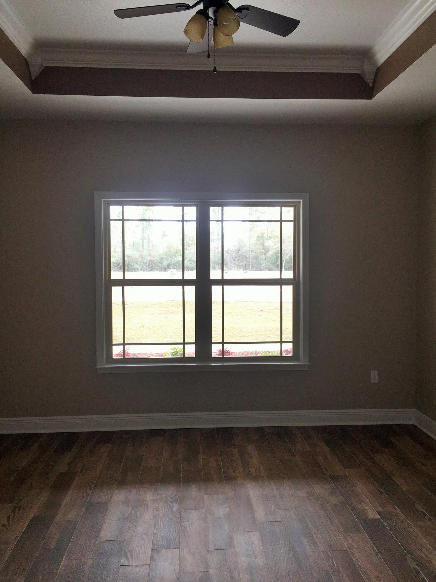 4011 Happy Trails Road Crestview, FL 32539 - Photo 11 of 19 a view of an empty room with wooden floor and a window