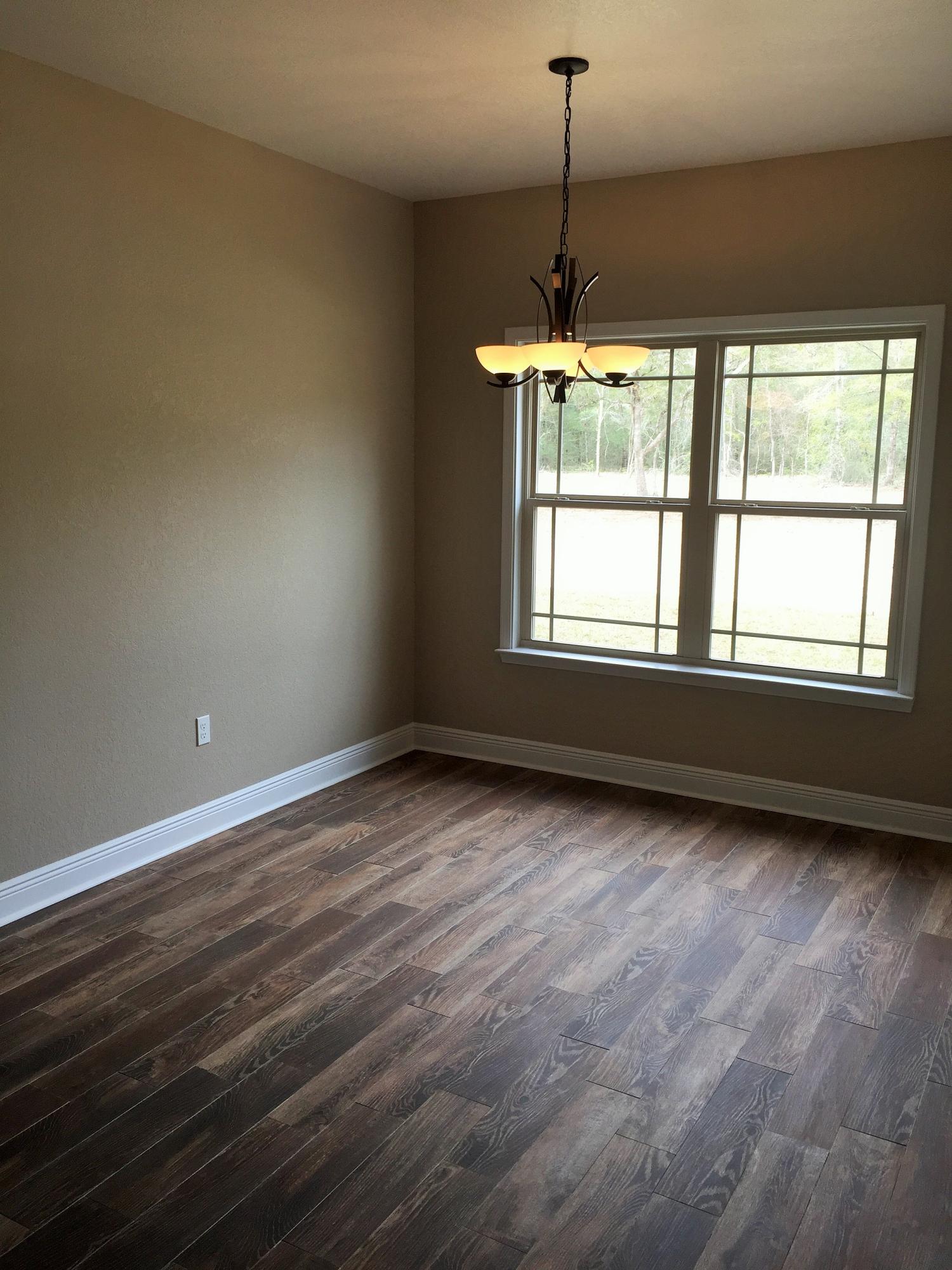 4011 Happy Trails Road Crestview, FL 32539 - Photo 12 of 19 a view of an empty room with wooden floor and a window