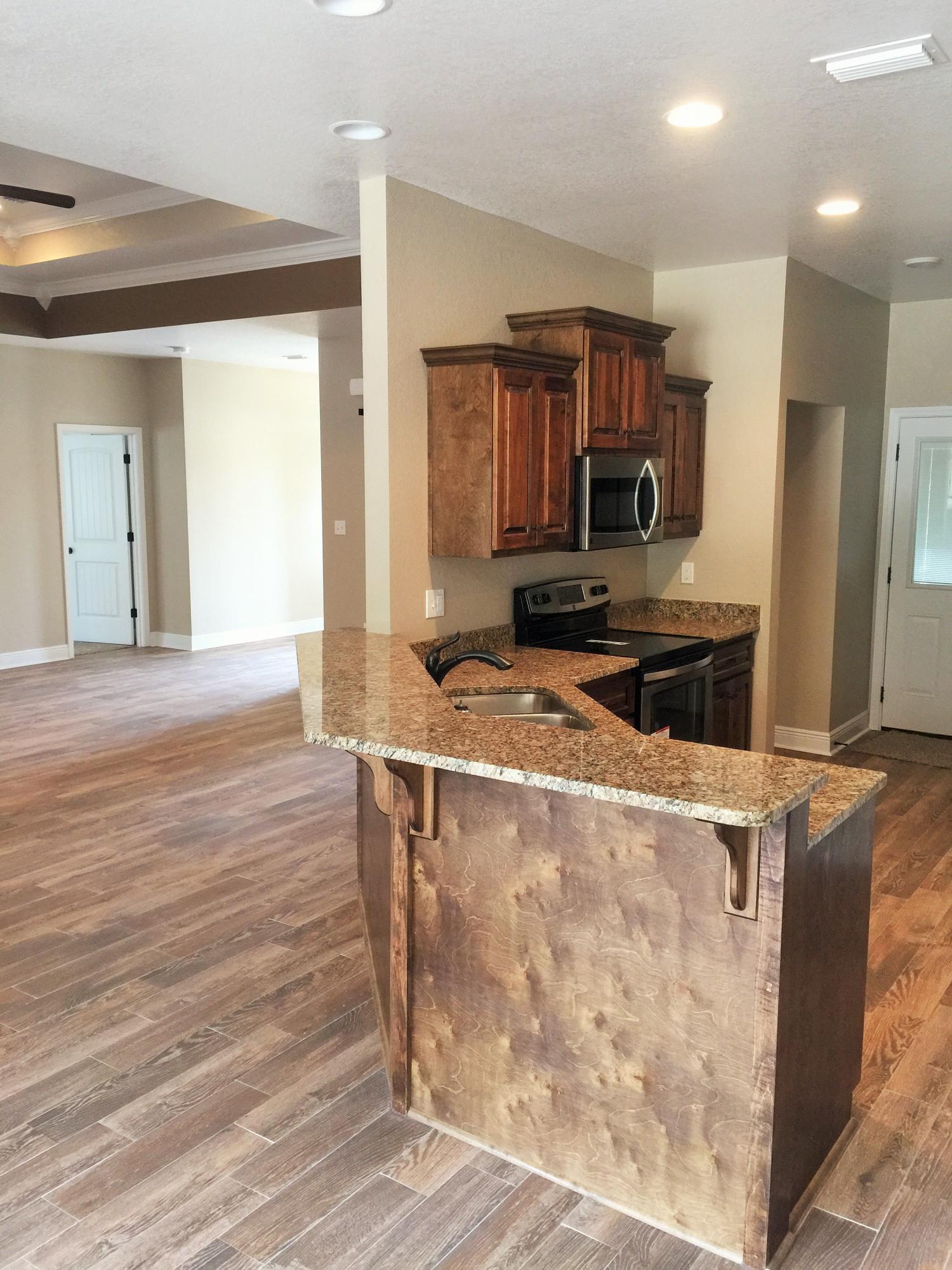 4011 Happy Trails Road Crestview, FL 32539 - Photo 13 of 19 a kitchen with kitchen island wooden floors and stainless steel appliances
