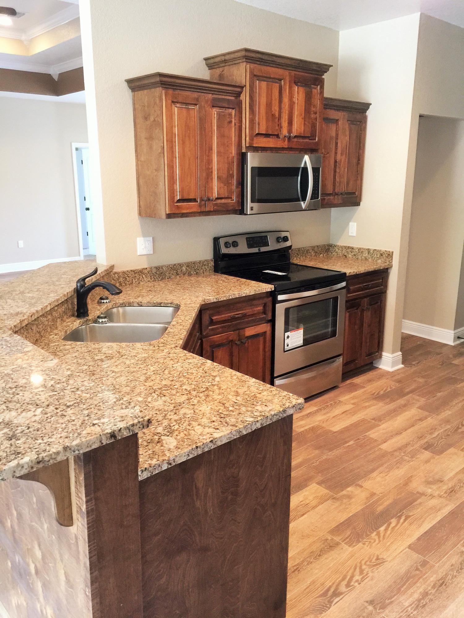4011 Happy Trails Road Crestview, FL 32539 - Photo 14 of 19 a kitchen with stainless steel appliances granite countertop a stove a sink and a microwave