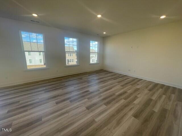 912 Channel Drop Loop Zebulon, NC 27597 - Photo 8 of 25 an empty room with wooden floor and windows