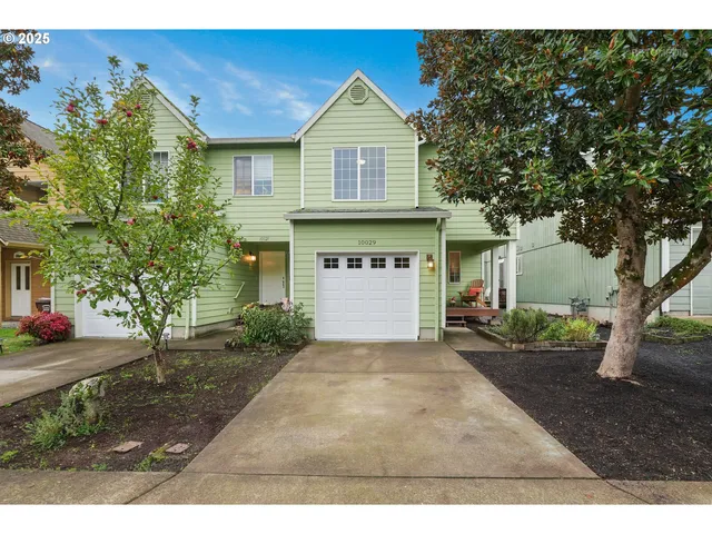 a front view of a house with a yard and garage