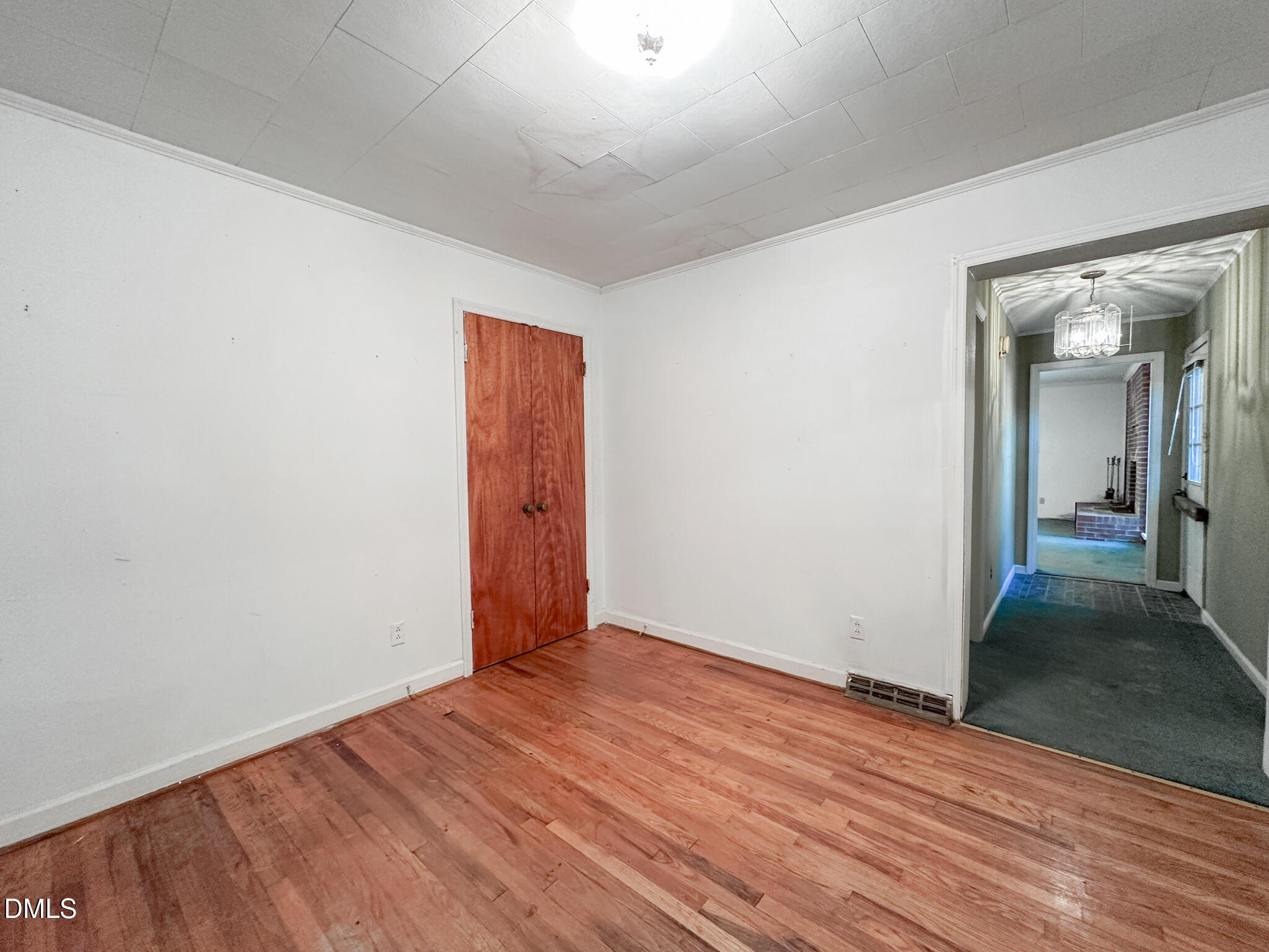 188 Jones Chapel Road Norlina, NC 27563 - Photo 35 of 71 an empty room with wooden floor and way to kitchen