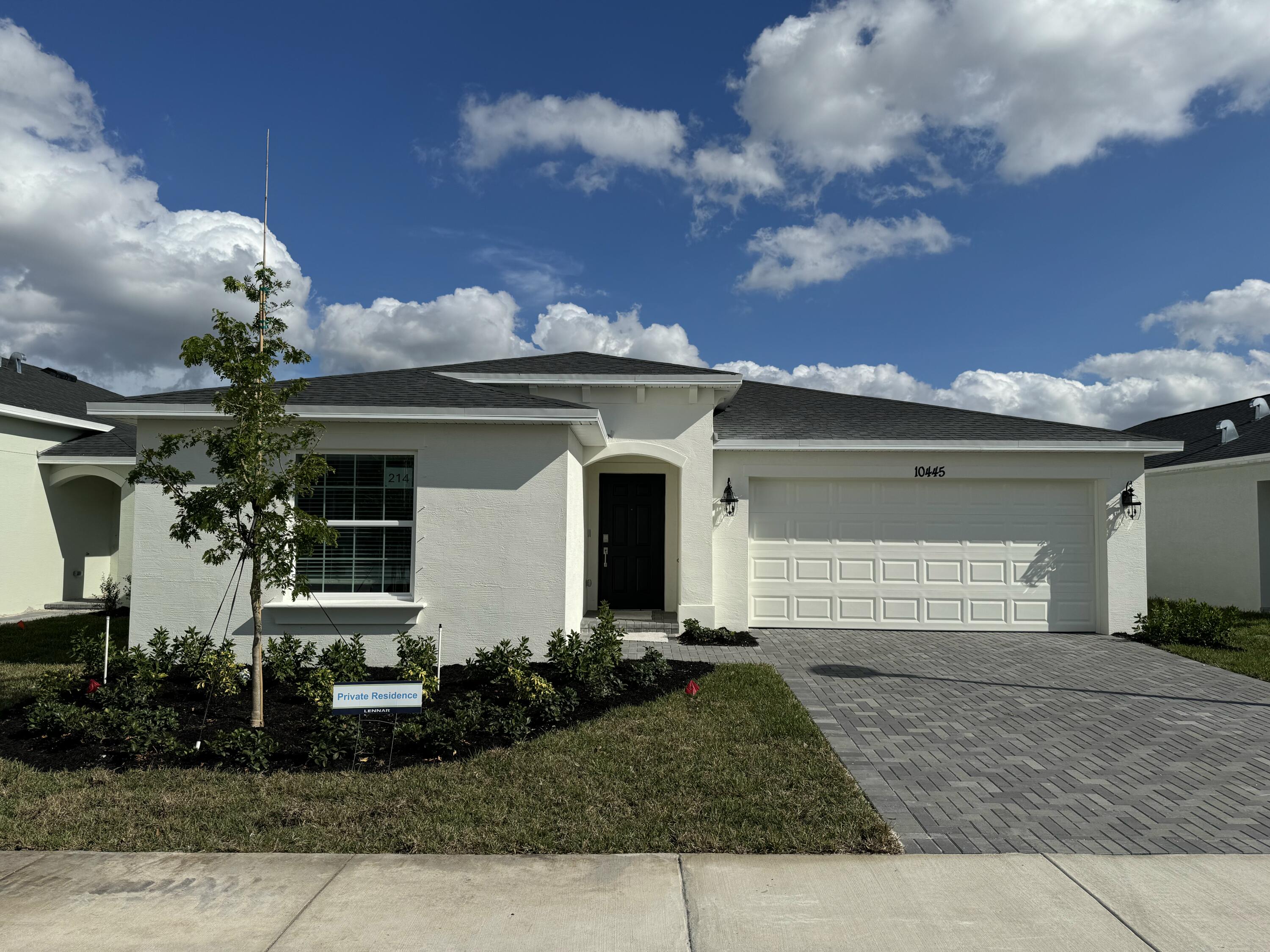 10445 Northwest Suncrest Loop Port Port St. Lucie, FL 34987 - Photo 1 of 45 a front view of a house with garden