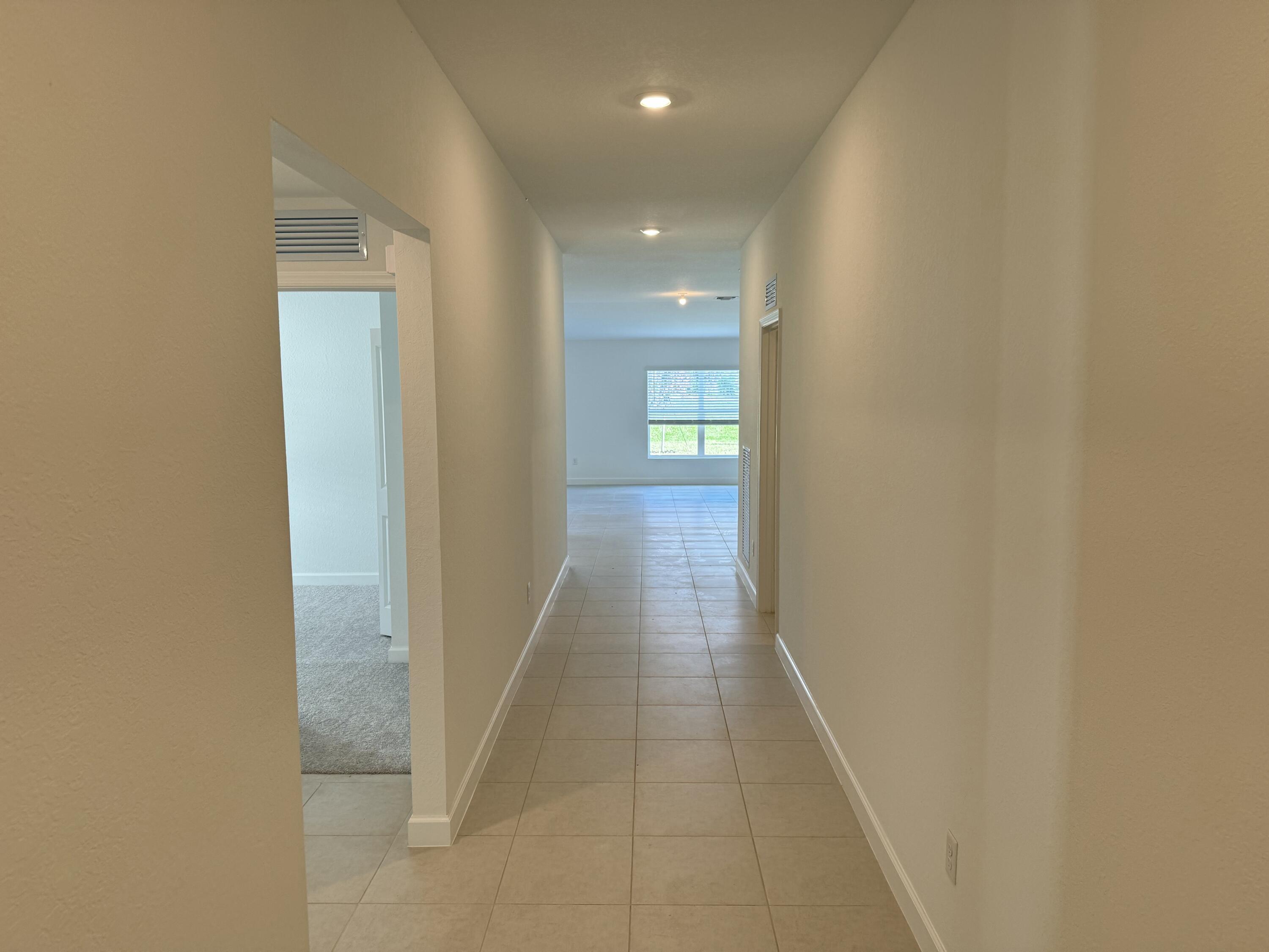 10445 Northwest Suncrest Loop Port Port St. Lucie, FL 34987 - Photo 12 of 45 a view of a hallway with wooden floor